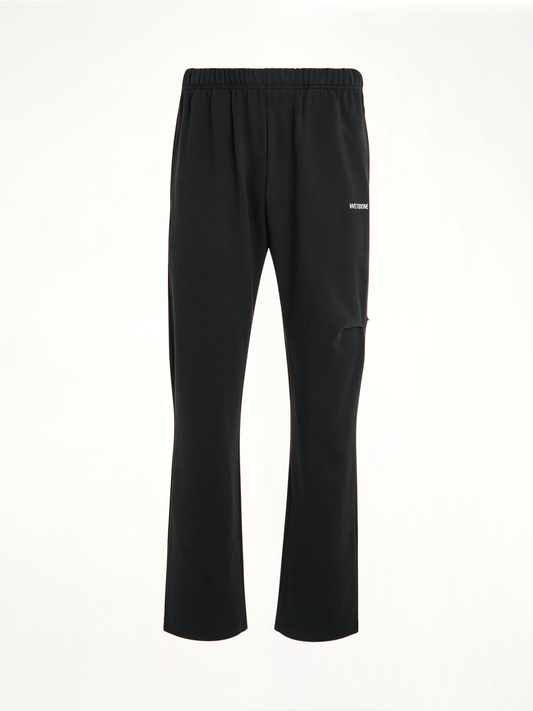 Image of a model wearing Pants. Productname: WE11DONE Back Logo Wide Jogger Pants in Black colour by brand - WE11DONE
