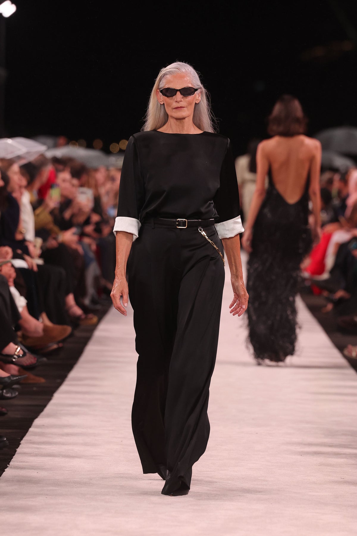 Image of a model wearing Tops. Product name - Black Satin Acetate Relaxed Split Hem Tee in Black colour by brand - Carla Zampatti