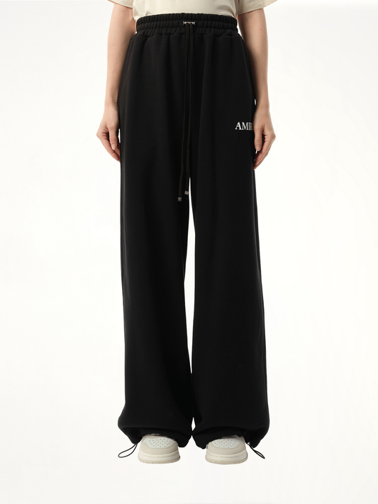 Image of a model wearing Pants. Productname: AMIRI Core logo Flare Sweatpant in BLACK colour by brand - AMIRI