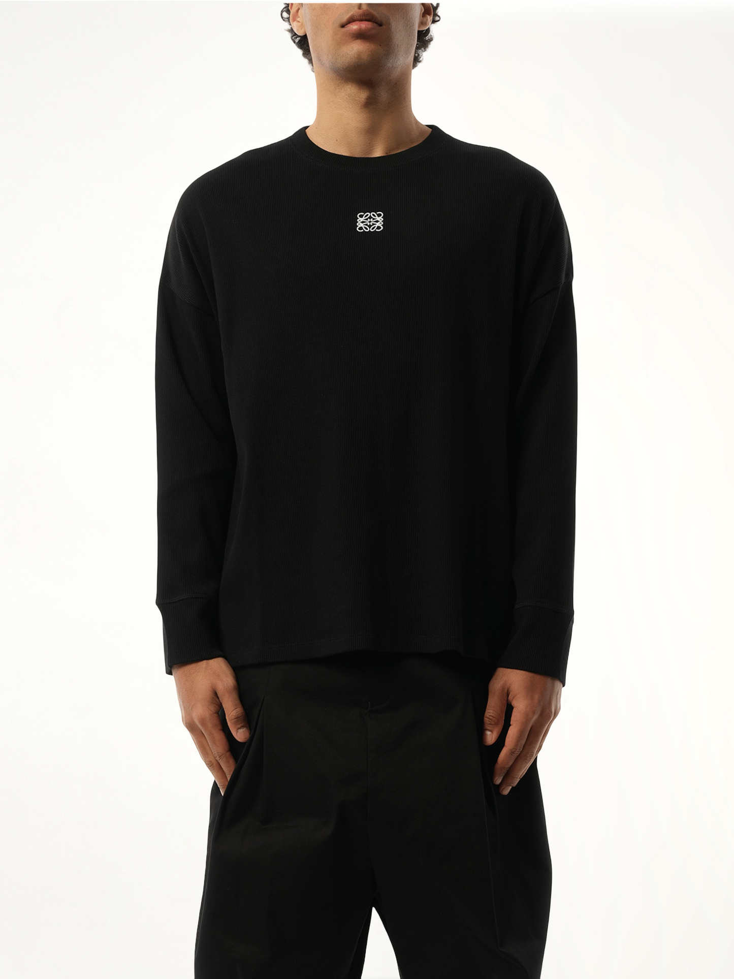 Image of a model wearing Tops. Product name - Long Sleeve Anagram T-Shirt in Black colour by brand - LOEWE