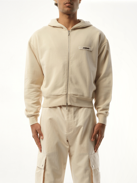 Image of a model wearing Outerwear. Productname: JACQUEMUS Le Hoodie Zip Gros Grain in BEIGE colour by brand - JACQUEMUS