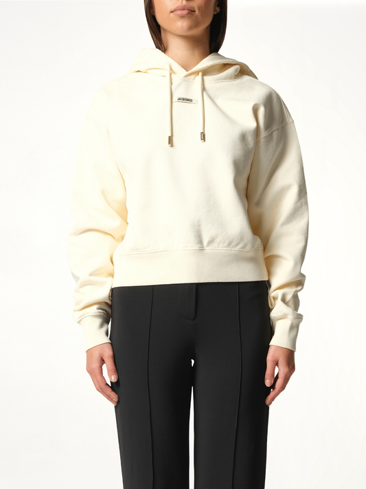 Image of a model wearing Outerwear. Productname: JACQUEMUS Le Hoodie Gros Grain in BEIGE colour by brand - JACQUEMUS