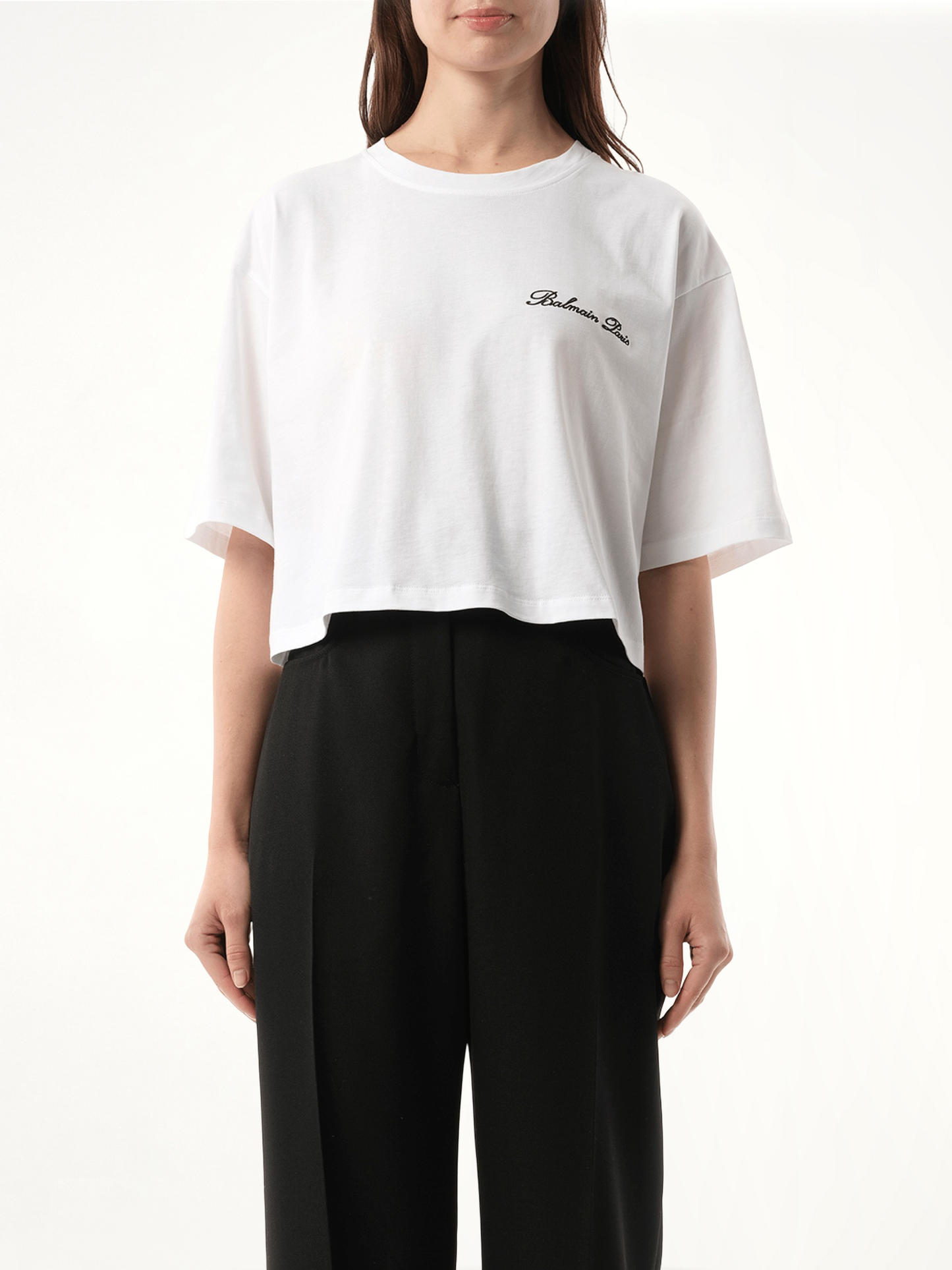 Image of a model wearing Tops. Product name - Balmain Signatured Embroidered Crop Top in White colour by brand - BALMAIN