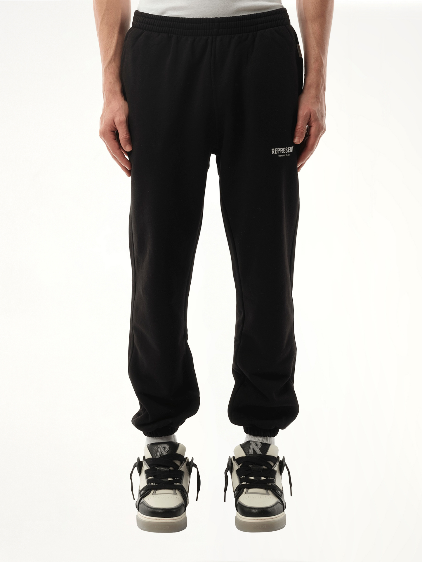 Image of a model wearing Pants. Product name - Represent Owners Club Sweatpants in Black colour by brand - REPRESENT