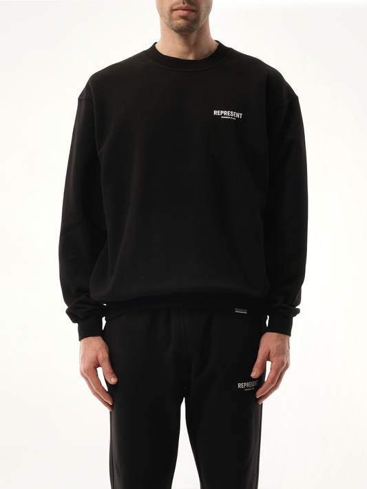 Image of a model wearing Outerwear. Product name - Represent Owners Club Sweatshirt in Black colour by brand - REPRESENT
