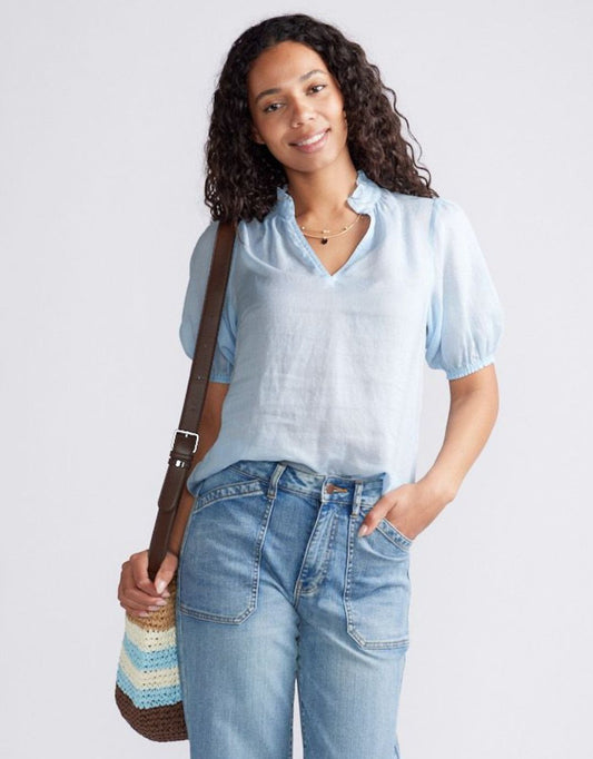 Image of a model wearing Tops. Product name - Camden Ruffle Blouse Ice Blue in Ice Blue colour by brand - White & Co.