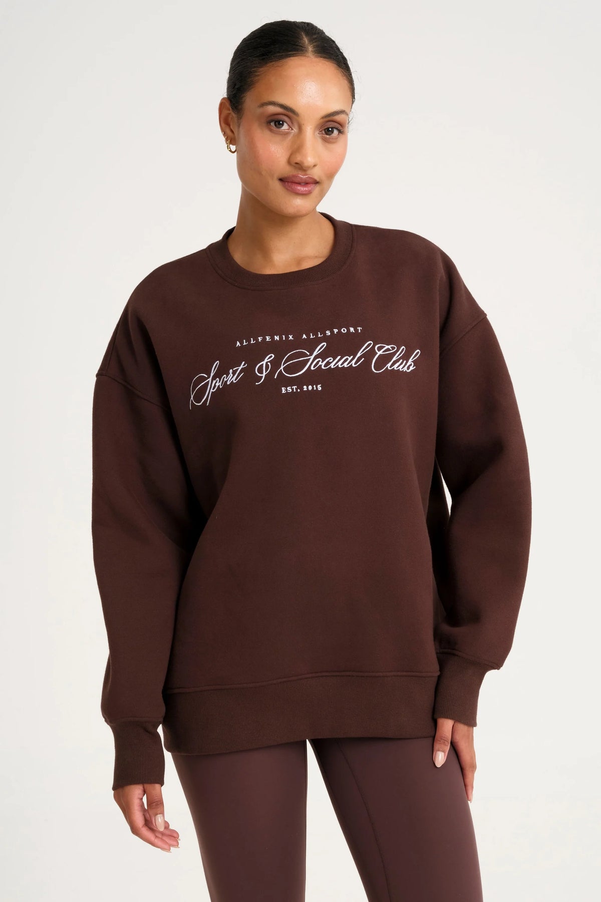 Image of a model wearing Outerwear. Product name - Collegiate Graphic Crew Neck Jumper in Espresso colour by brand - All Fenix
