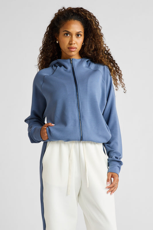 Image of a model wearing Outerwear. Product name - Soft Essentials Cropped Hoodie in Blue colour by brand - All Fenix