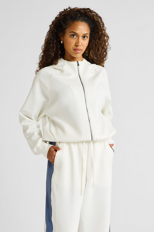 Image of a model wearing Outerwear. Product name - Soft Essentials Cropped Hoodie in Chalk colour by brand - All Fenix