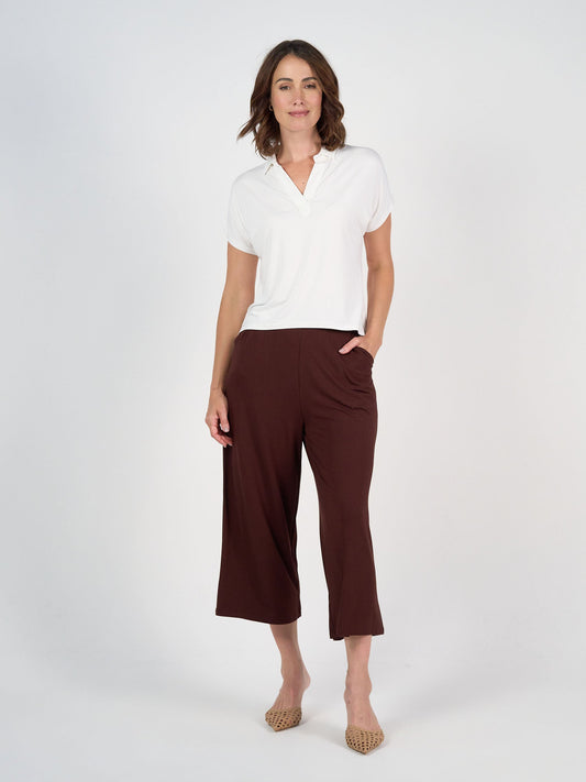 Image of a model wearing Tops. Product name - Rush Bamboo Short Sleeve Collared Polo Top Cream in Cream colour by brand - Lou Lou
