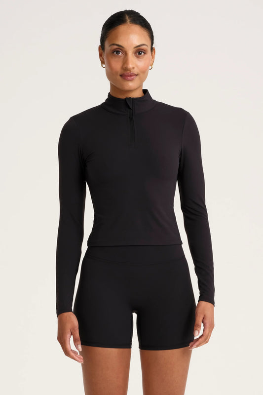 Image of a model wearing Tops. Product name - ALLFENIX CloudCore Lite 1/4 Zip Long Sleeve in Black colour by brand - All Fenix