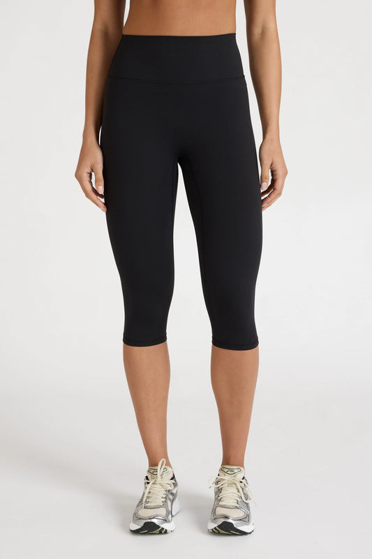Image of a model wearing Pants. Product name - EcoSculpt Capri Legging in Black colour by brand - All Fenix