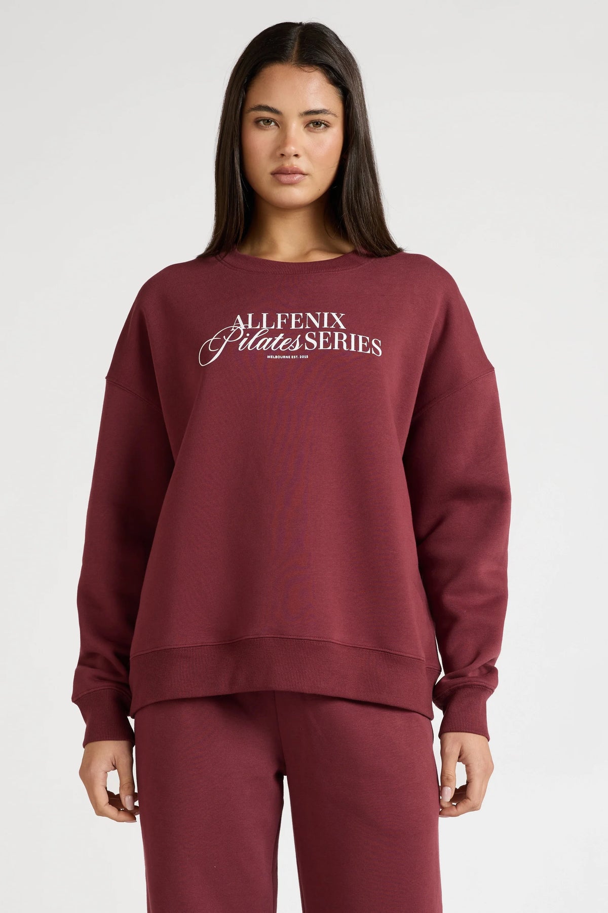 Image of a model wearing Outerwear. Product name - Pilates Series Crew Jumper in Burgundy colour by brand - All Fenix