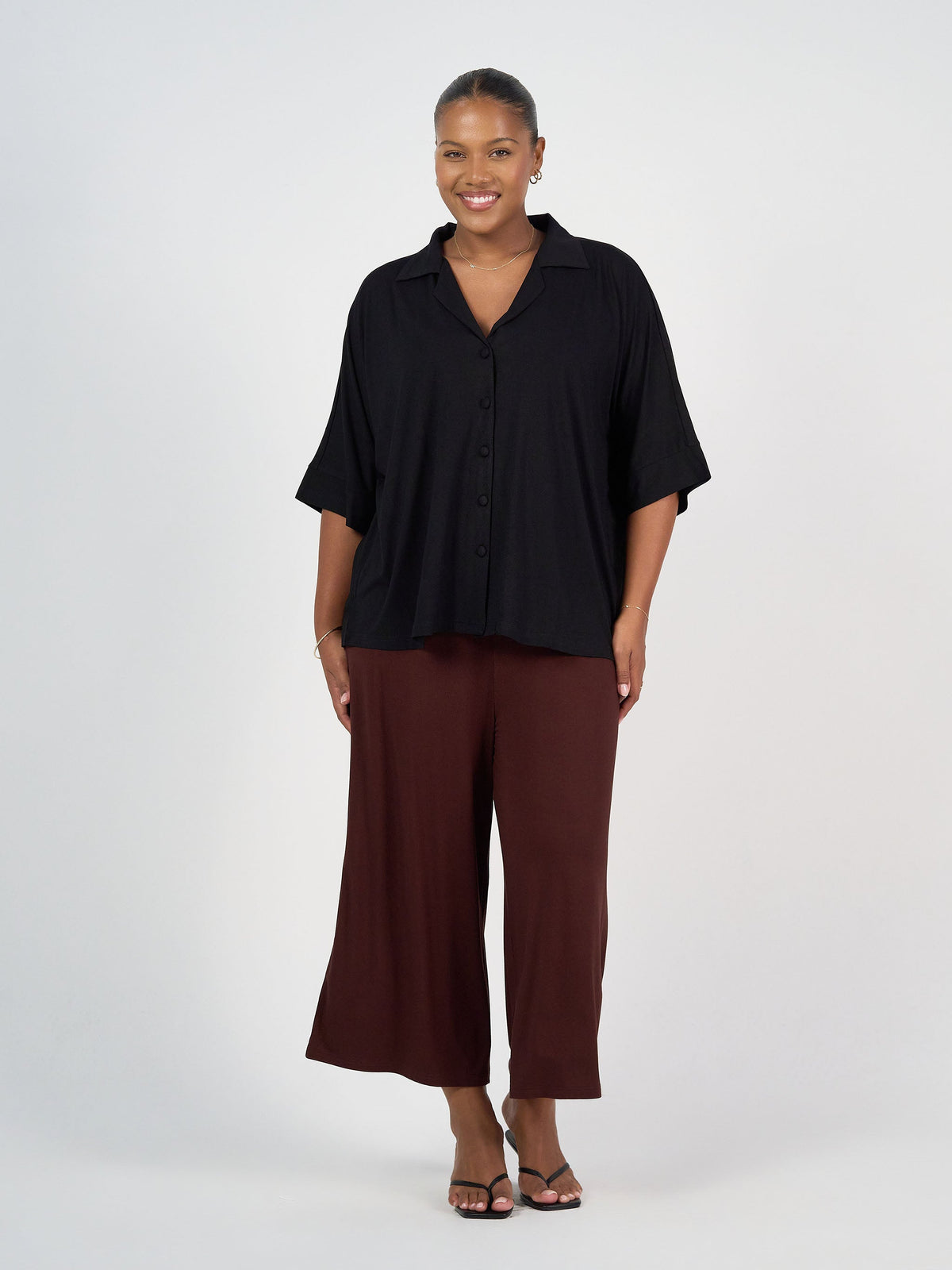 Image of a model wearing Tops. Product name - Alanis 3/4 Sleeve Collared Bamboo Shirt Black in Black colour by brand - Lou Lou