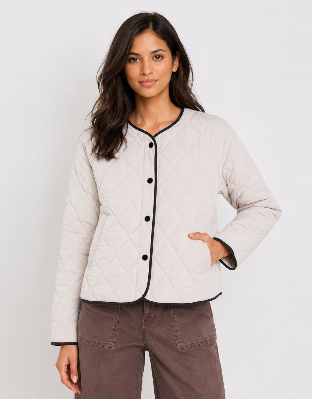 Image of a model wearing Outerwear. Product name - Apex Collarless Quilted Contrast Piping Puffer Jacket Bone in Bone colour by brand - Stories Be Told