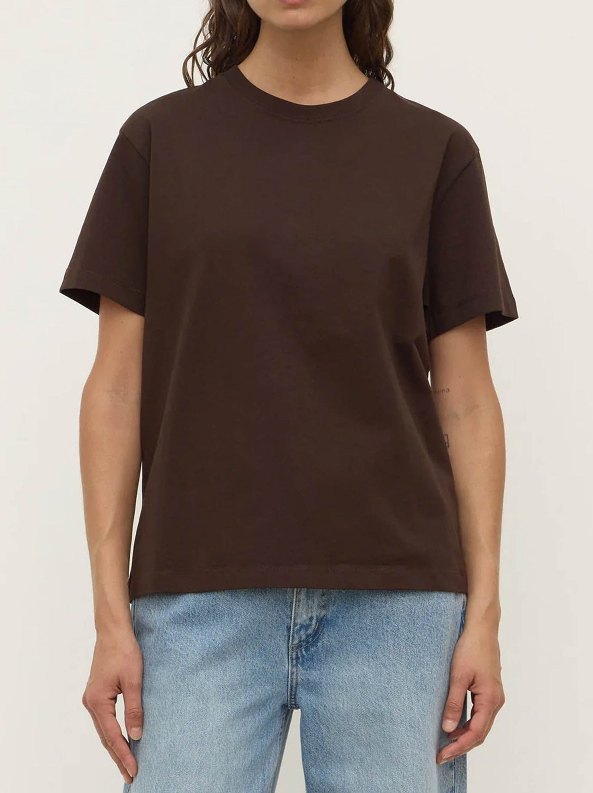 Image of a model wearing Tops. Product name - ASSEMBLY LABEL ORGANIC BASE TEE in Drift colour by brand - Assembly Label
