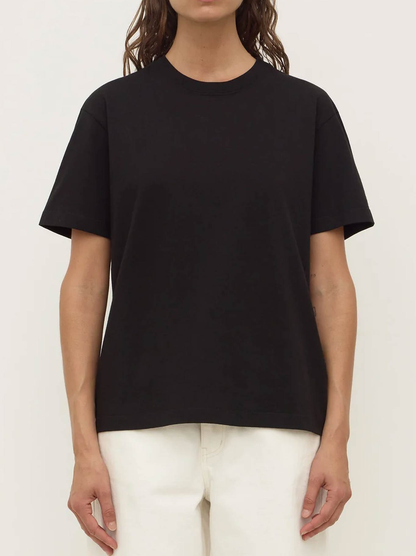 Image of a model wearing Tops. Product name - ASSEMBLY LABEL ORGANIC BASE TEE in Black colour by brand - Assembly Label