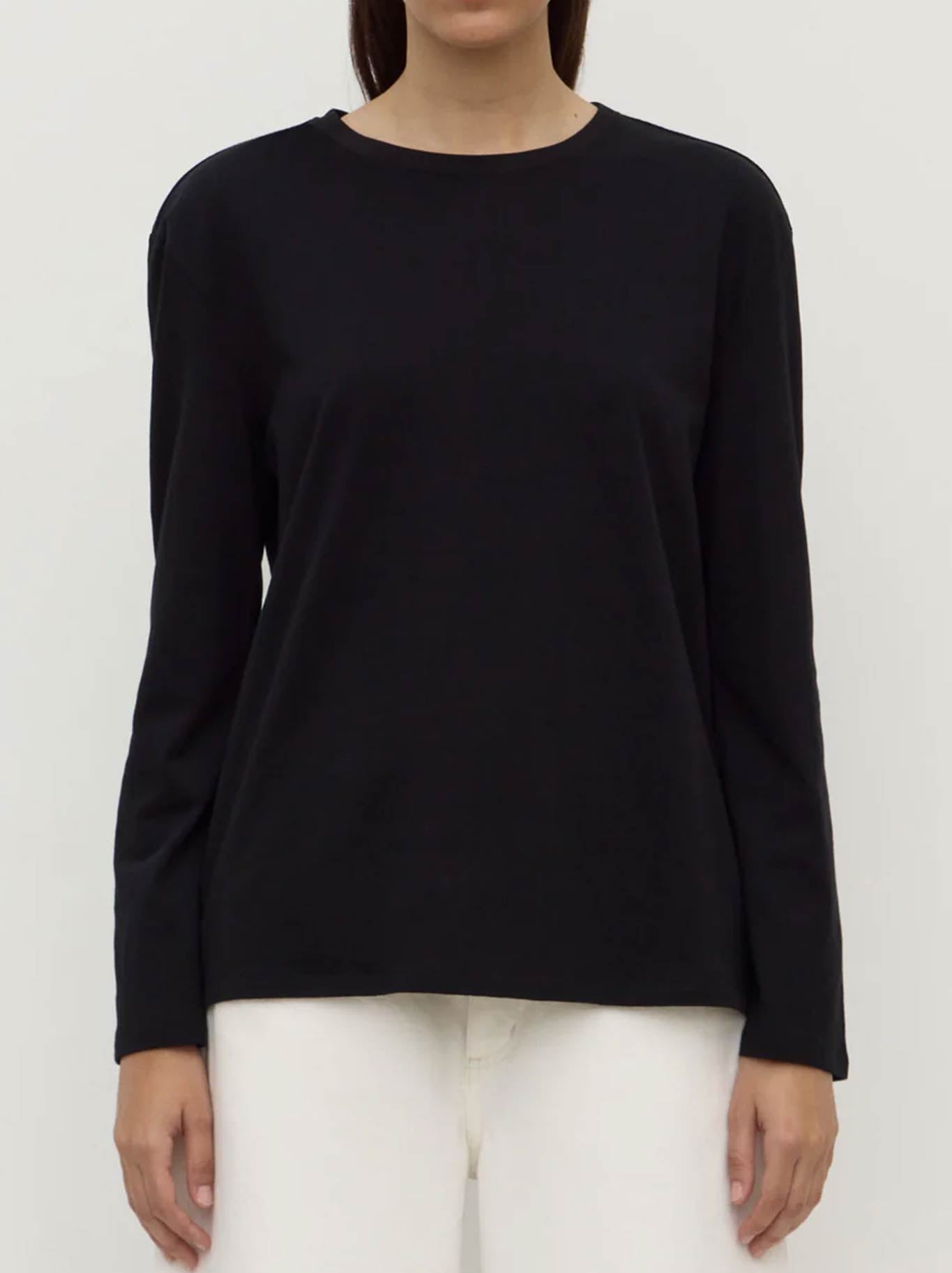 Image of a model wearing Tops. Product name - ASSEMBLY LABEL THEA LONG SLEEVE TEE WHITE in Black colour by brand - Assembly Label