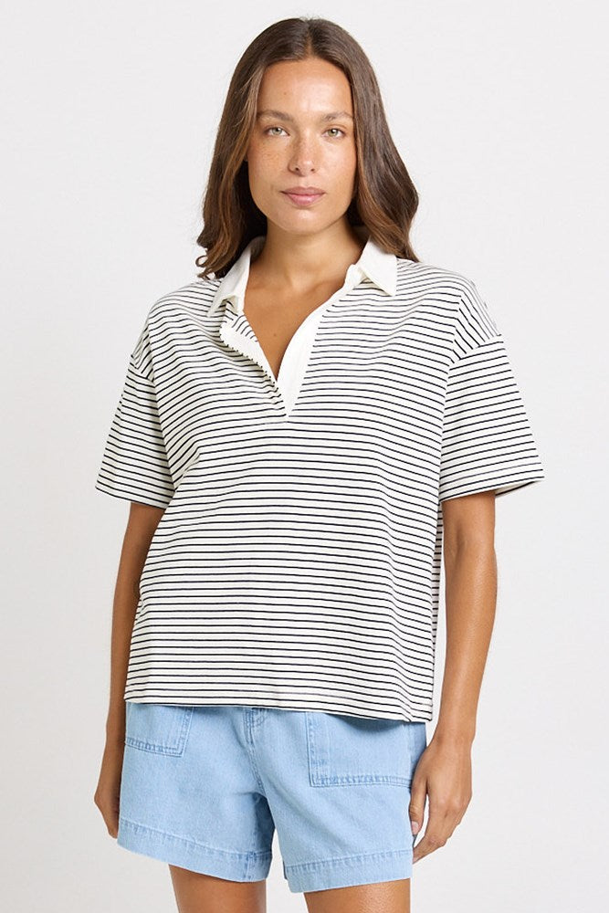 Image of a model wearing Tops. Product name - Freddy Cotton Polo Top White/Navy Stripe in White/Navy Stripe colour by brand - Betty Basics