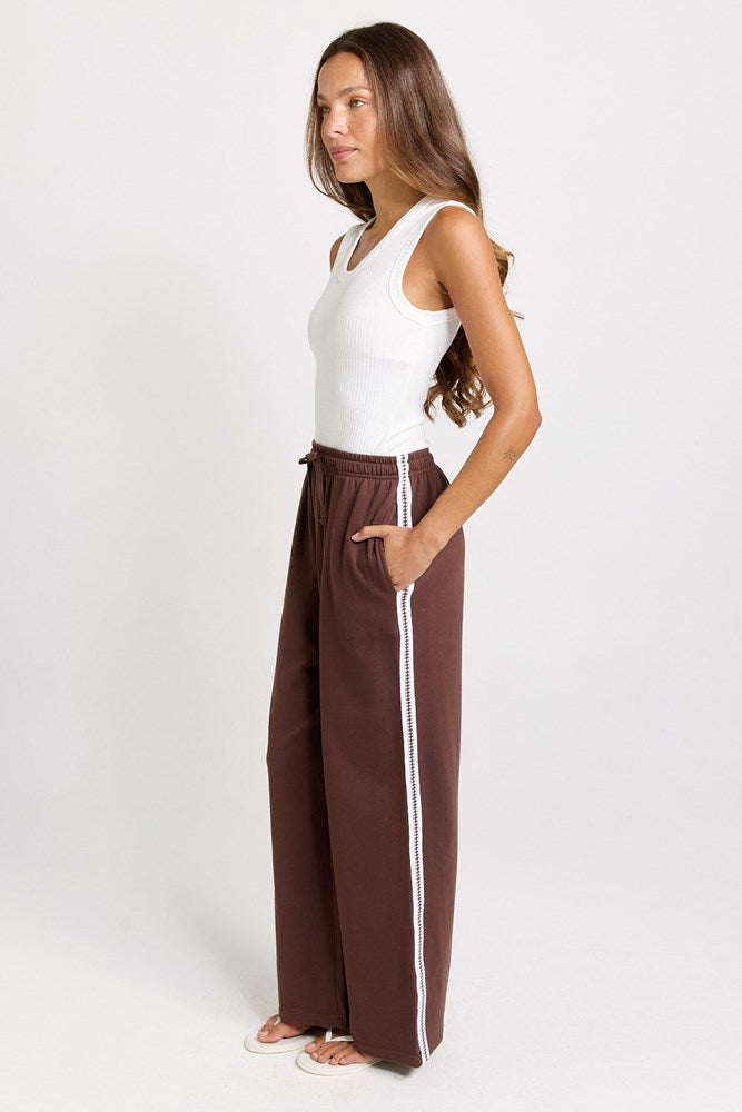 Image of a model wearing Pants. Product name - Nikki Relax Cotton Jogger Chocolate in Chocolate colour by brand - Betty Basics