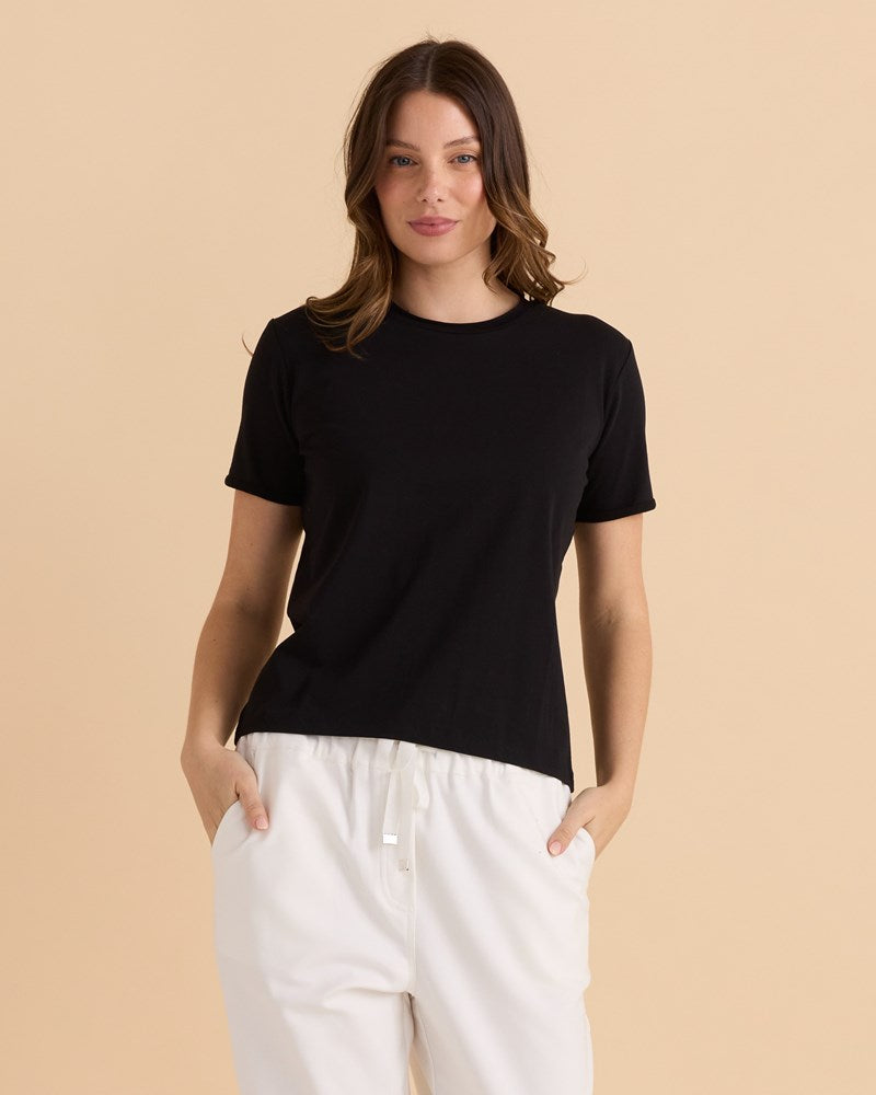 Image of a model wearing Tops. Productname: Betty Basics Cotton Slim Fit Tee Black in Black colour by brand - Betty Basics