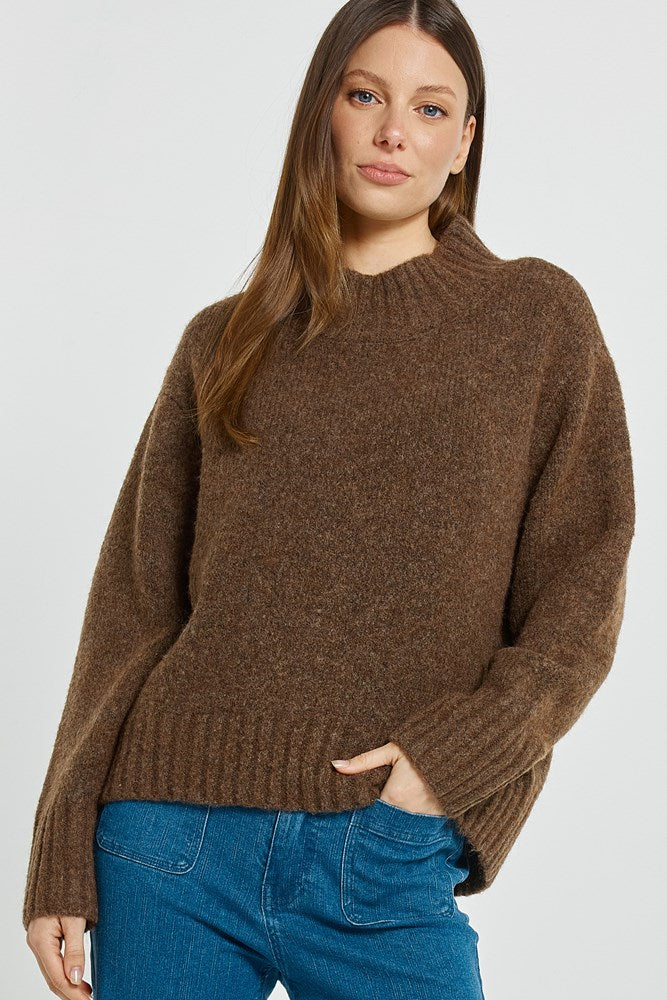 Image of a model wearing Outerwear. Product name - Lola Jumper Chocolate in Chocolate colour by brand - Betty Basics