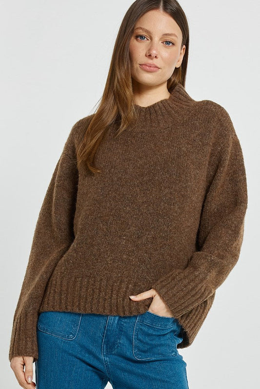 Image of a model wearing Outerwear. Product name - Lola Jumper Chocolate in Chocolate colour by brand - Betty Basics