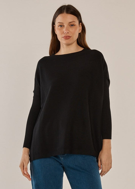 Image of a model wearing Outerwear. Product name - Blakely Batwing Sweater Black in Black colour by brand - Betty Basics