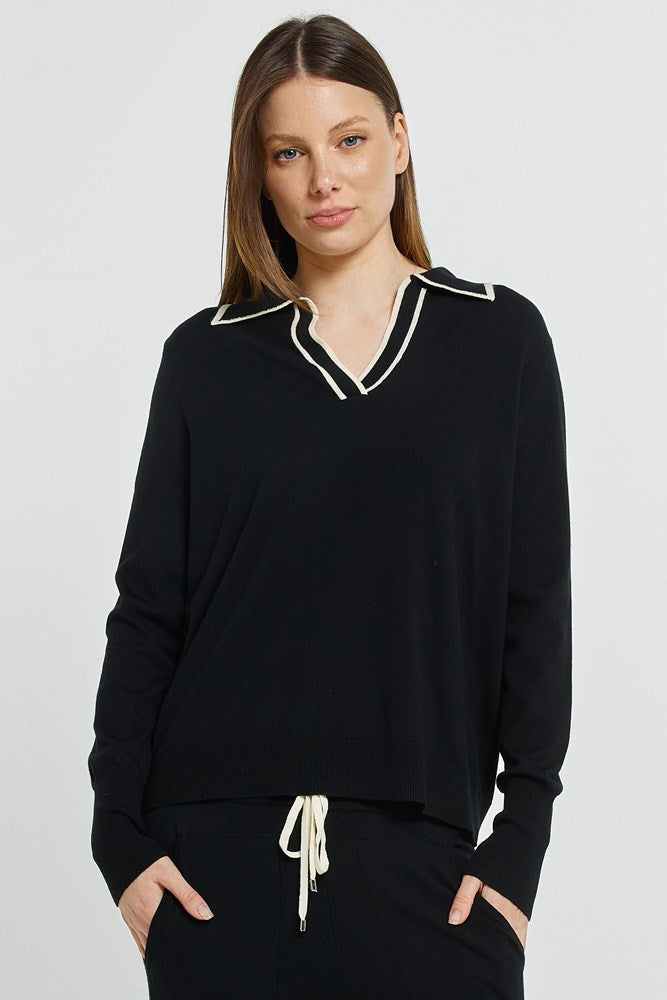 Image of a model wearing Outerwear. Product name - Makenna Polo Sweater Black in Black colour by brand - Betty Basics