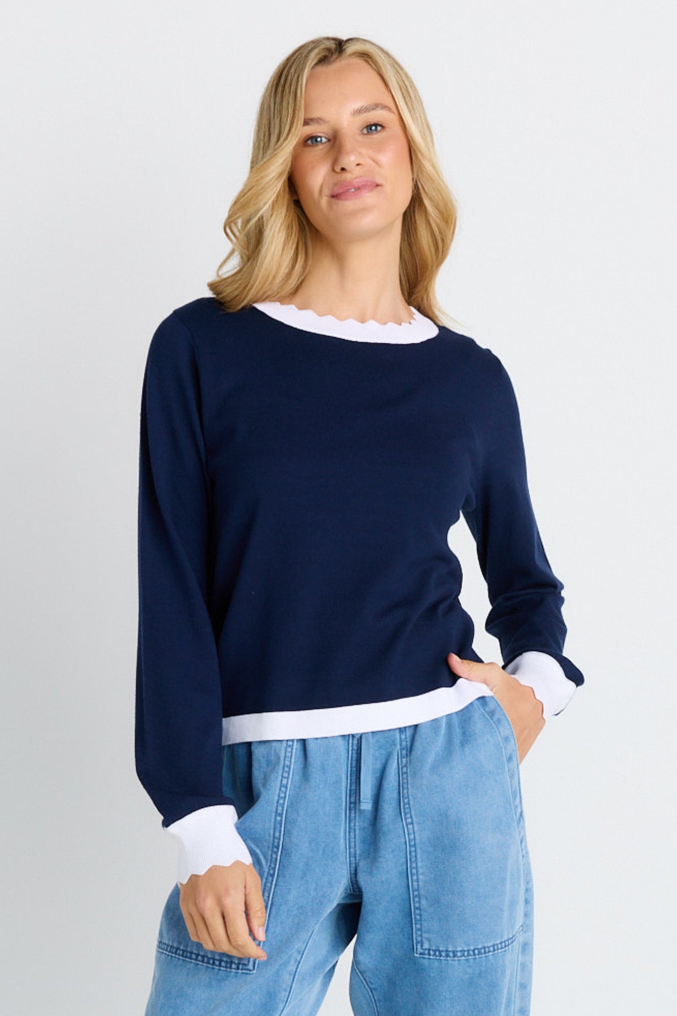 Image of a model wearing Outerwear. Product name - Scallop Knit Sweater in Navy colour by brand - Betty Basics