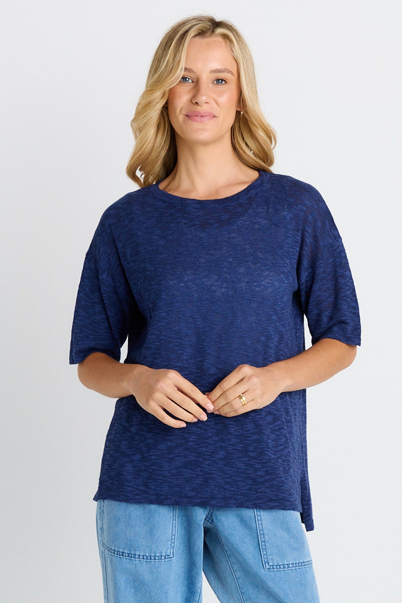 Image of a model wearing Tops. Product name - Eleni Knit Tee Navy in Navy colour by brand - Betty Basics