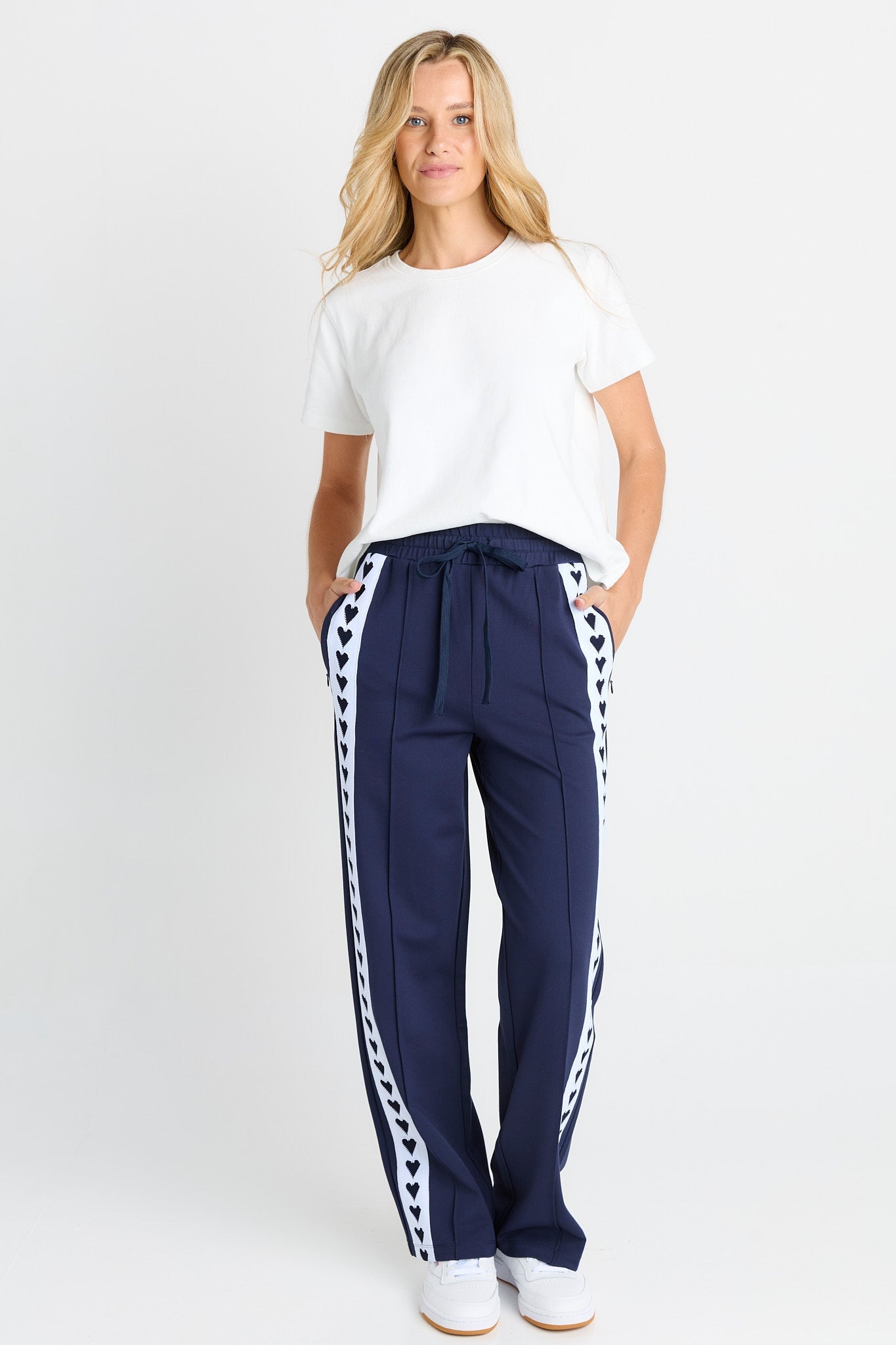Image of a model wearing Pants. Product name - Jamie Trackpant Navy in Navy colour by brand - Betty Basics