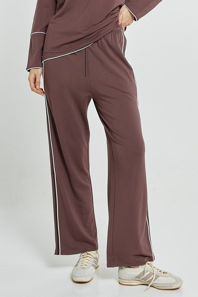Image of a model wearing Pants. Product name - Evelyn Wide Leg Jogger Nutmeg in Nutmeg colour by brand - Betty Basics