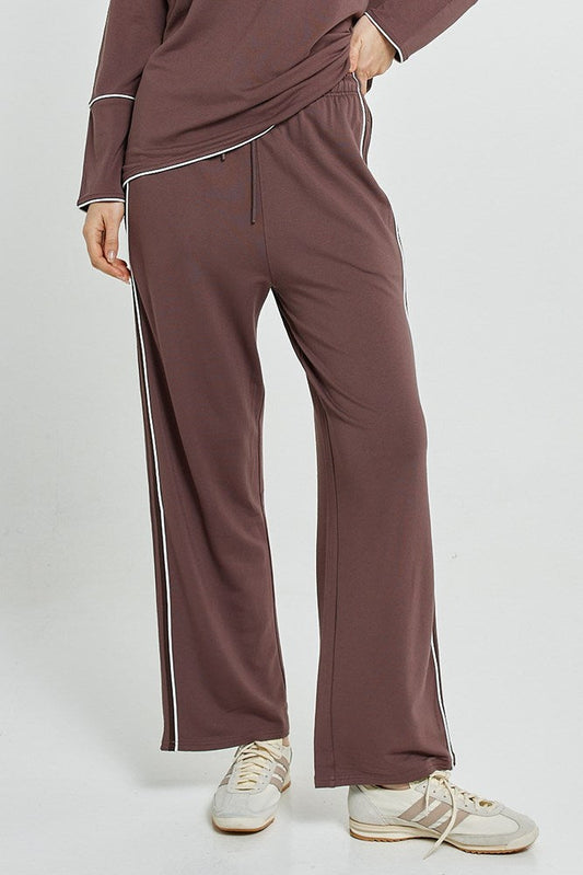 Image of a model wearing Pants. Product name - Evelyn Wide Leg Jogger Nutmeg in Nutmeg colour by brand - Betty Basics