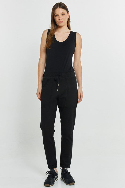 Image of a model wearing Pants. Product name - Noelle Jogger Black in Black colour by brand - Betty Basics