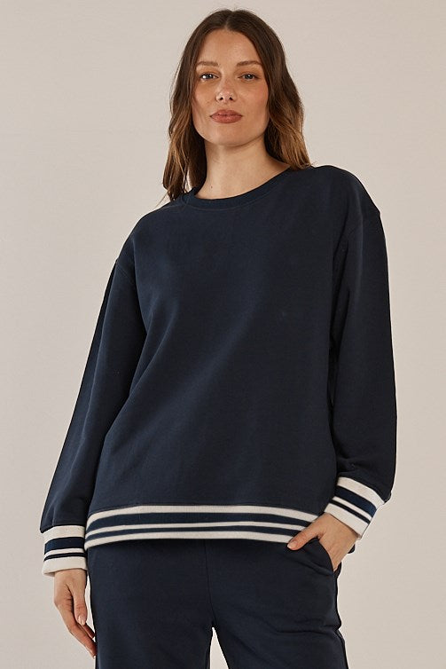 Image of a model wearing Outerwear. Product name - Stazie Sweatshirt Navy in Navy colour by brand - Betty Basics