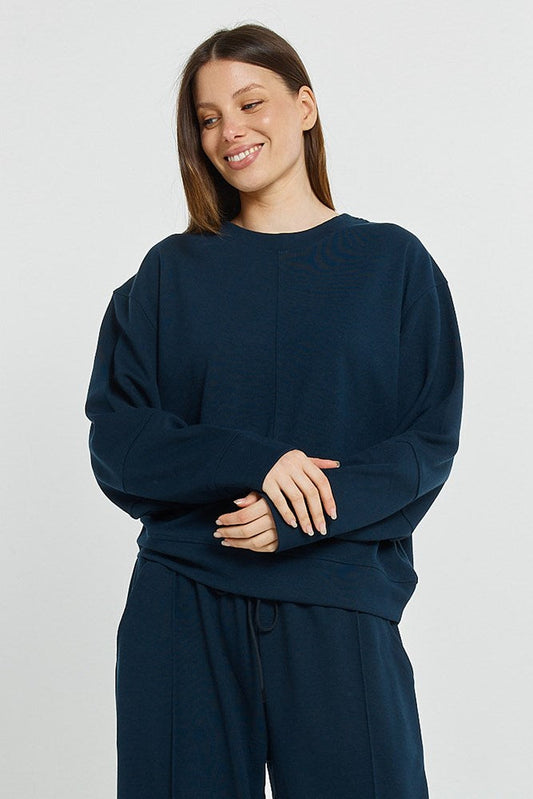 Image of a model wearing Outerwear. Product name - Elona Top Navy in Navy colour by brand - Betty Basics