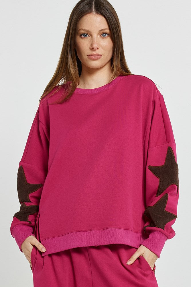 Image of a model wearing Outerwear. Product name - Saskia Sweatshirt Mulberry in Mulberry colour by brand - Betty Basics