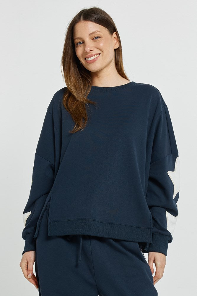 Image of a model wearing Outerwear. Product name - Saskia Sweatshirt Navy in Navy colour by brand - Betty Basics