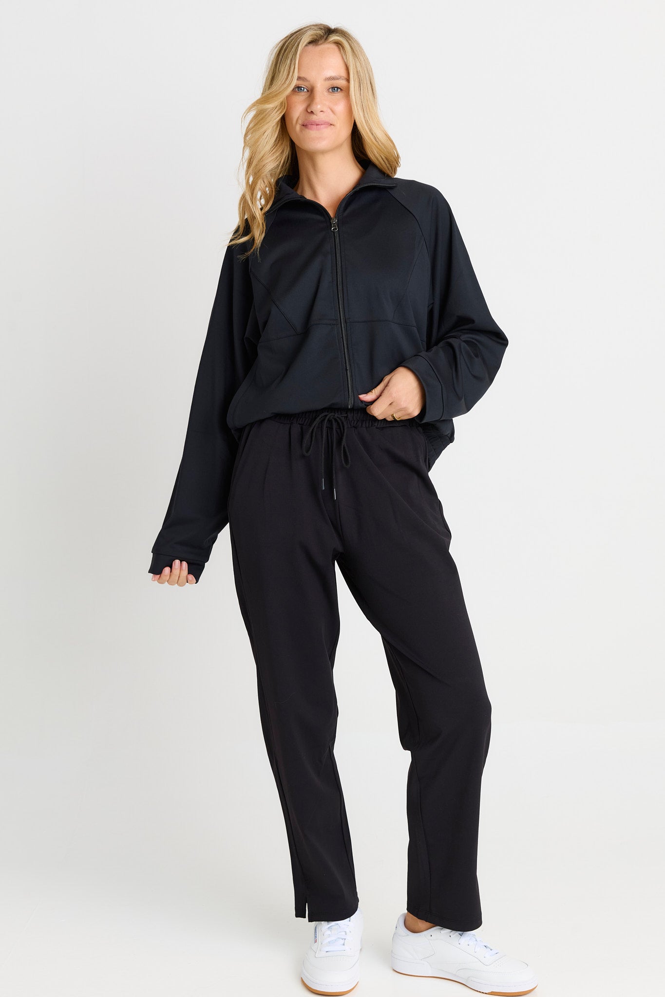 Image of a model wearing Pants. Product name - Milla Travel Jogger Black in Black colour by brand - Betty Basics