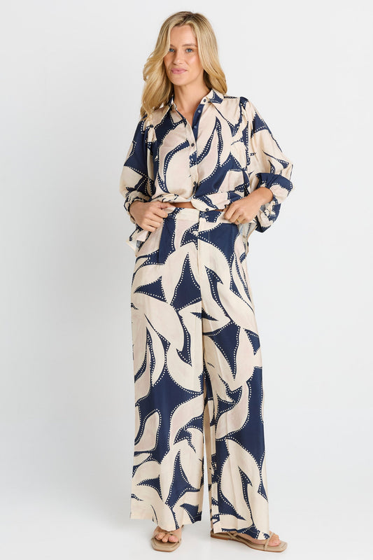 Image of a model wearing Pants. Product name - Zander Pant Navy Floral Print in Navy Floral Print colour by brand - Betty Basics