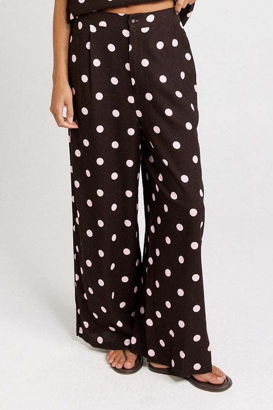Image of a model wearing Pants. Product name - Zander Pant in Pink/Choc Polka Dot colour by brand - Betty Basics