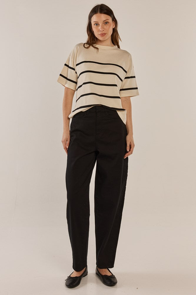 Image of a model wearing Pants. Product name - Barrel Leg Chino Black in Black colour by brand - Betty Basics