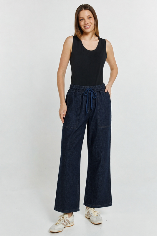 Image of a model wearing Pants. Product name - Quinn Stretch Jogger Blue Wash in Blue Wash colour by brand - Betty Basics