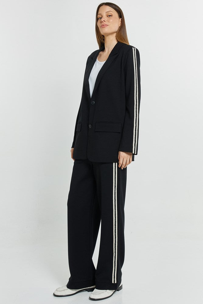 Image of a model wearing Pants. Product name - Bien Trim Jogger Black Trim in Black Trim colour by brand - Betty Basics