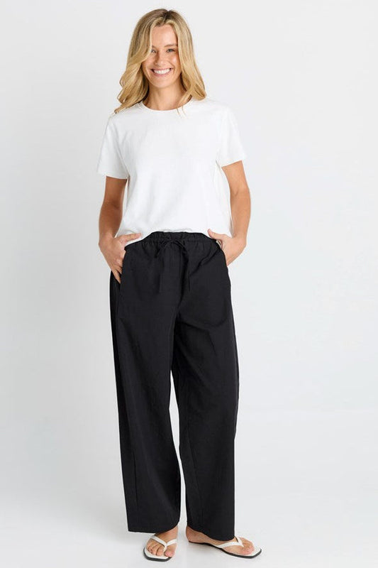 Image of a model wearing Pants. Product name - Patsy Pant Black in Black colour by brand - Betty Basics