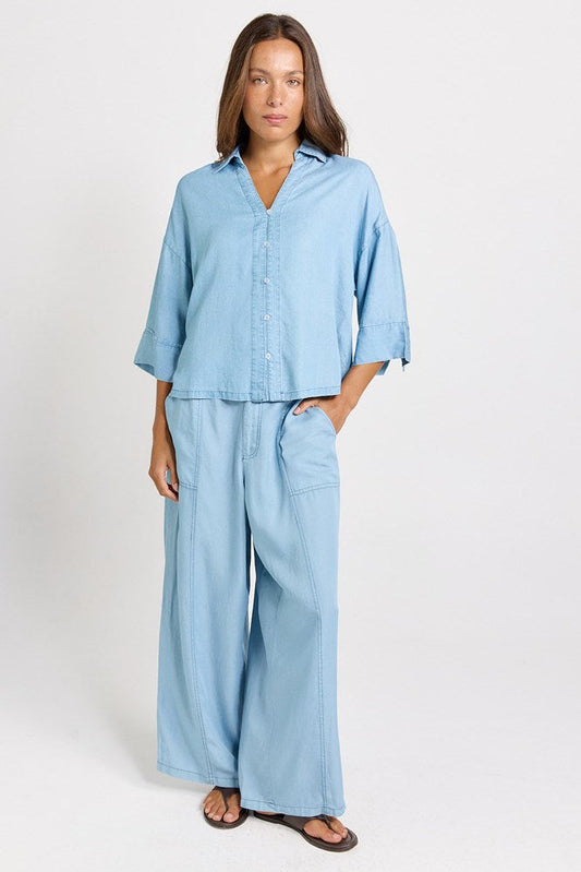 Image of a model wearing Pants. Product name - Emmy Lyocell Wide Leg Pant Mid Wash in Mid Wash colour by brand - Betty Basics