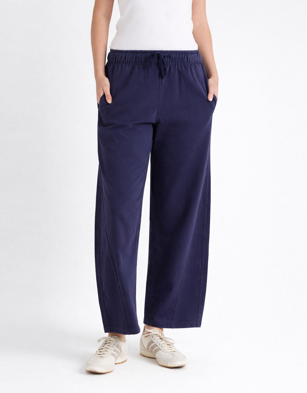 Image of a model wearing Pants. Product name - Barrel Leg Sweatpant Navy in Navy colour by brand - Betty Basics