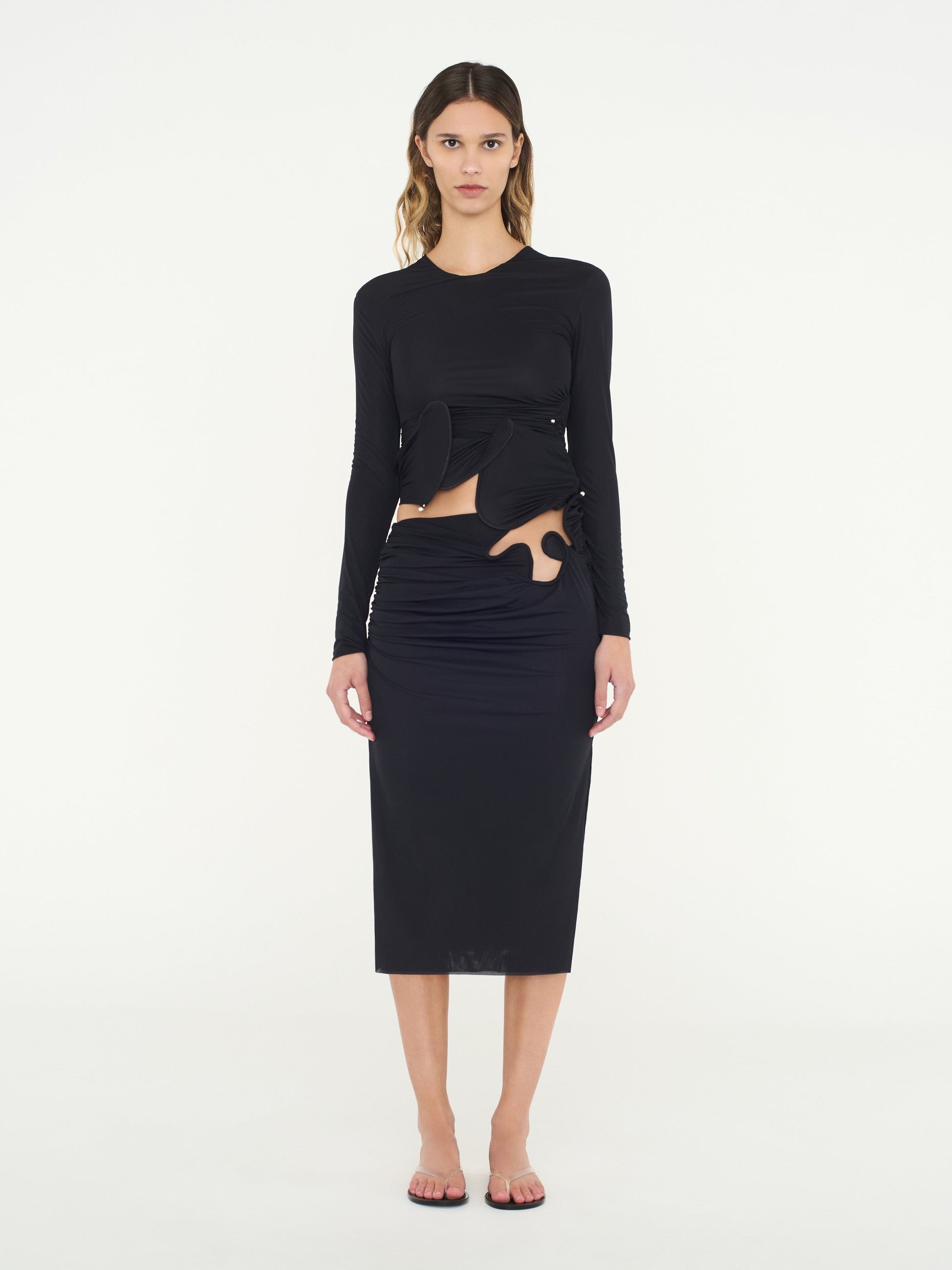 Image of a model wearing Skirts. Product name - Venus Midi Skirt in Black colour by brand - Christopher Esber