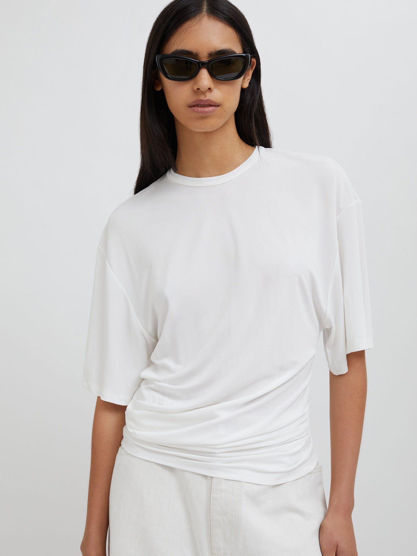 Image of a model wearing Tops. Productname: Christopher Esber Side Cowl Waist Tee in Milk colour by brand - Christopher Esber